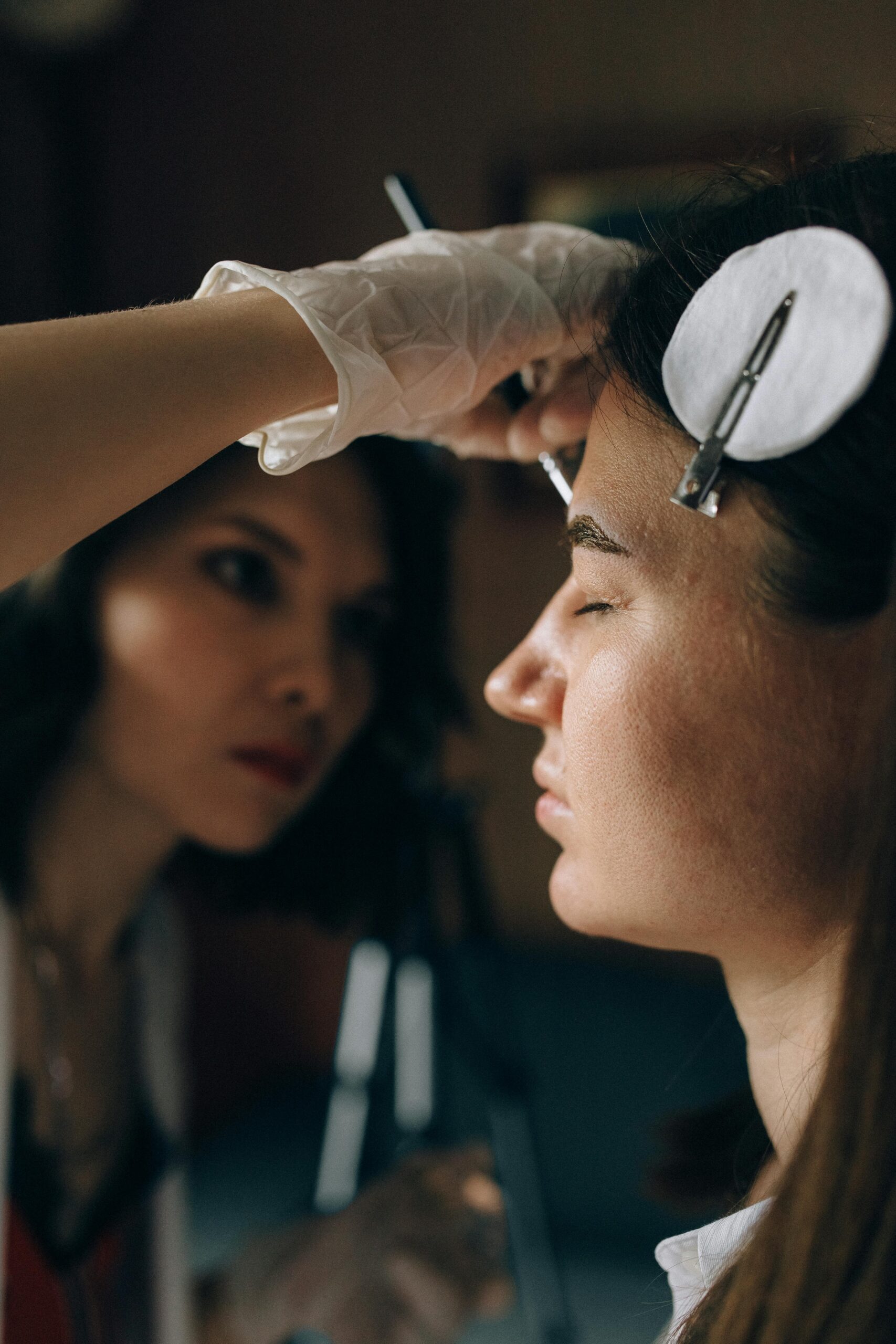 A makeup artist skillfully applies makeup to a client's face in a professional setting.